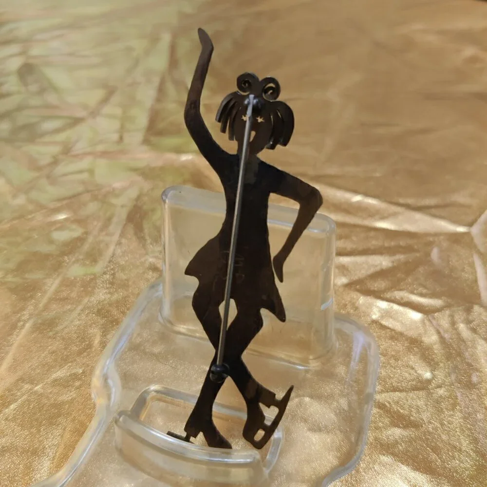 Brooch of a whimsical girl Figure Skater. Signed GB.